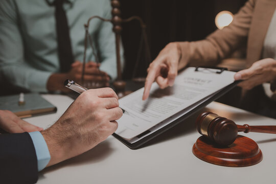 A group of lawyers is discussing contract documents that must be presented to a client, Lawyers brainstorm to revise important documents that must be submitted to the Supreme Court.
