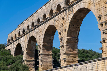 Low angle partial view of the aqueduct bridge Pont du Gard over the Gardon river near Vers-Pont-du-Gard, France with well-preserved arched tiers, built by 1st-century Romans