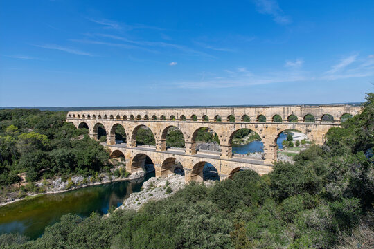 High angle view of the aqueduct bridge Pont du Gard over the Gardon river near Vers-Pont-du-Gard, France with well-preserved arched tiers, built by 1st-century Romans