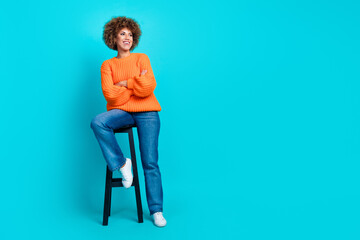 Fototapeta na wymiar Full length portrait of charming nice person sit chair crossed hands look empty space isolated on turquoise color background