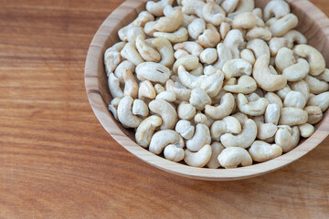 Cashews in a wooden bowl. Nuts are healthy food. Wooden background. Cashew kernel