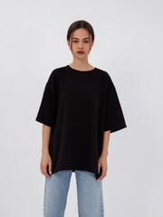 mockup of a black loose-fitting t-shirt on a young beautiful girl