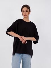 mockup of a black loose-fitting t-shirt on a young beautiful girl