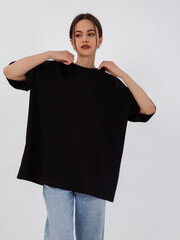 mockup of a black loose-fitting t-shirt on a young beautiful girl