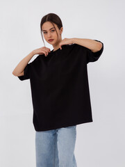 mockup of a black loose-fitting t-shirt on a young beautiful girl