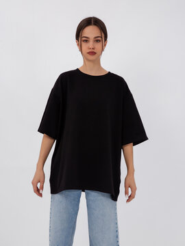 mockup of a black loose-fitting t-shirt on a young beautiful girl
