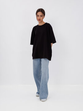 mockup of a black loose-fitting t-shirt on a young beautiful girl