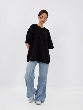 mockup of a black loose-fitting t-shirt on a young beautiful girl