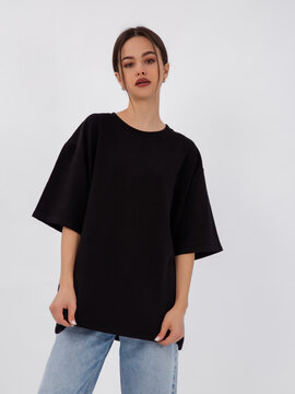 mockup of a black loose-fitting t-shirt on a young beautiful girl