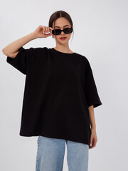 mockup of a black loose-fitting t-shirt on a young beautiful girl