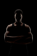 Basketball player against black background. Serious concentrated african american man silhouette.