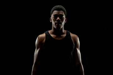 Fototapeta na wymiar Basketball player against black background. Serious concentrated african american man silhouette.