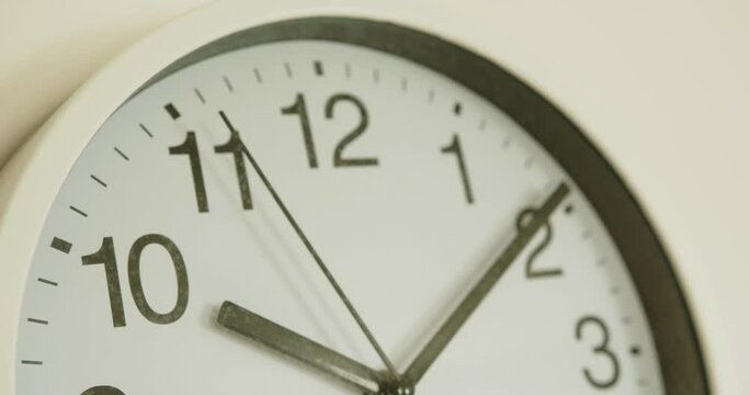 close-up of a white wall clock showing the time 10:10