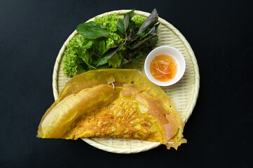 Sizzling rice pancake with green leaves and sauce