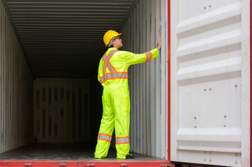 Asian male technician worker standing in container to inspect empty container condition at cargo shipping warehouse yard
