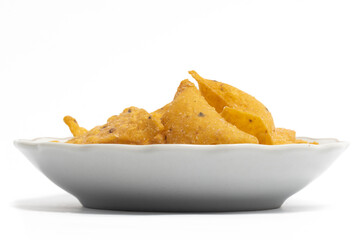 Crispy corn tortilla nachos chips in a small white plate isolated on white background clipping path
