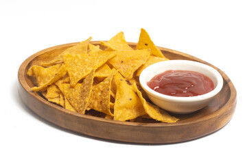Crispy corn tortilla nachos chips with sauce in a wooden plate isolated on white background clipping path