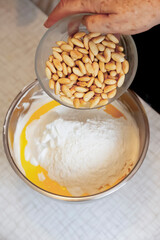 Ageless Artistry: Senior's Hands Blend Flour, Butter, Egg, and Almonds
