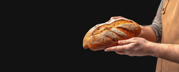 Baker man holding bread. loaf rye wheat bread. Long banner format. copy space for text