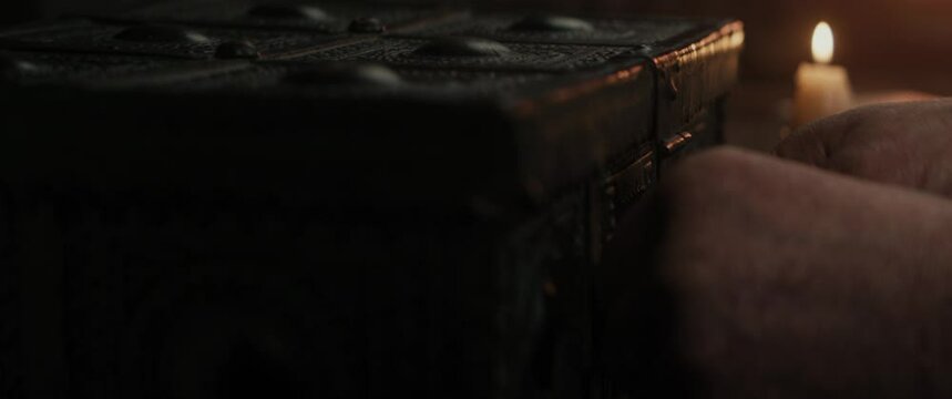 A captain's hand opens a chest and takes a sheet of paper