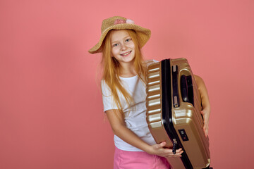 Redhead smiling teen girl holding suitcase wearing hat. Luggage, travelling, vacation.