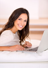 Woman, laptop and happy on sofa for portrait with remote work from home, living room or freelance editing. Person, writer and smile with pc on couch for typing, creativity and article in Barcelona