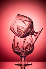 a composition of two empty glasses backlit on the pink background with gradient, advertisement or glassware cover, events, photography