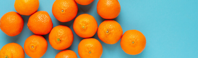 Line of fresh oranges top view banner. Vibrant photo of citrus fruits flat lay on blue background. Vitamin C