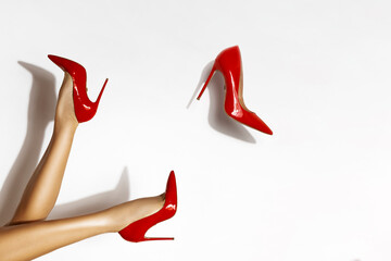 Isolated female legs in red high heels. Studio shoot.