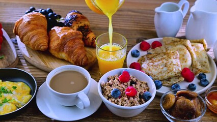 Breakfast served with coffee, orange juice, scrambled eggs, cereals, pancakes and croissants.