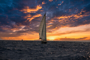 The Sailing Boat is cruising the Adriatic Sea in Rogoznica Croatia with a sunset orange but cloudy...