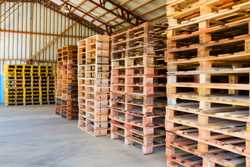 Warehouse interior with wooden pallets and windows. Industrial background