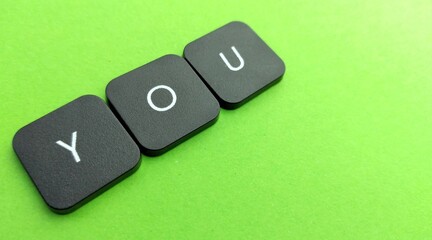 word you on black button on green background, business and finance concept