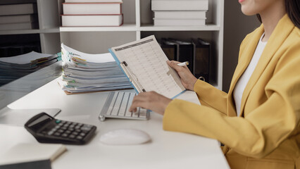 Asian female financial officer or auditing accountant calculates investment results on financial...