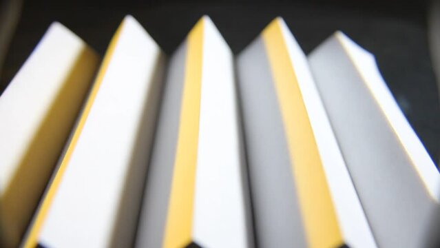 Papel de cartulina reciclado con pliegues repetitivos formando un patr&oacute;n acanalado en forma de escalera con tri&aacute;ngulos reflejados, presenta un videoclips de arte abstracto muy original.