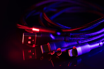 Different USB charging plugs on dark background. USB Type C, Micro USB, Usb lightning
