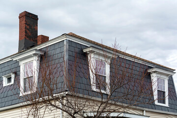 Obraz premium Mansard roof and dormers of a family house in Brighton on a winter day, MA, USA