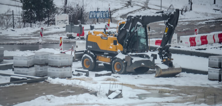 Polska Ostrowiec Świętokrzyski 9 lutego 2024 o 12:25. Koparka kołowa Volvo na zaśnieżonym placu budowy dr&oacute;g. Szwedzka silna maszyna budowlana stojąca na śniegu.
