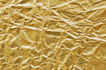 A sheet of golden metallic wrinkled foil as background