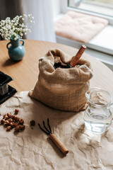 There is crumpled paper on a wooden table, and on it are small gardening tools, crocus bulbs, a bag...