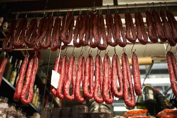 Hooks, butchery and dry sausage in shop for traditional food, groceries or products in Germany....
