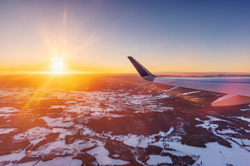 Plane fly at sunset over snowy mountains - 748732747