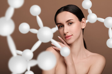 Beautiful woman with perfect healthy skin and molecular model on brown background. Innovative...