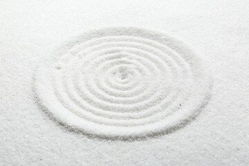 Zen rock garden. Circle pattern on white sand