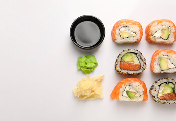 Delicious sushi rolls on white background, flat lay. Space for text