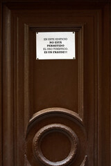 Image of a warning sign stuck on a brown door indicating the prohibition of tourist use of the...