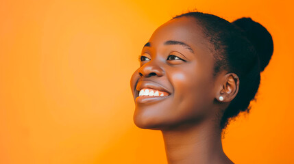 Portrait of a smiling African American girl on an isolated orange background.