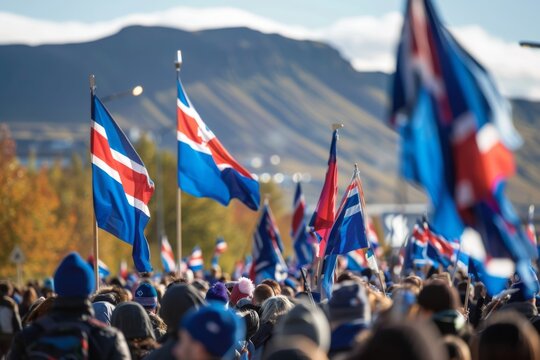 A sea of Icelandic flags ripple in the wind as a crowd gathers to celebrate a national event, with the majestic mountains as a backdrop.
