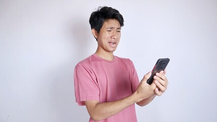 sad asian man holding smartphone