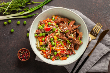Stewed vegetables with quinoa and beef in a bowl on the table.